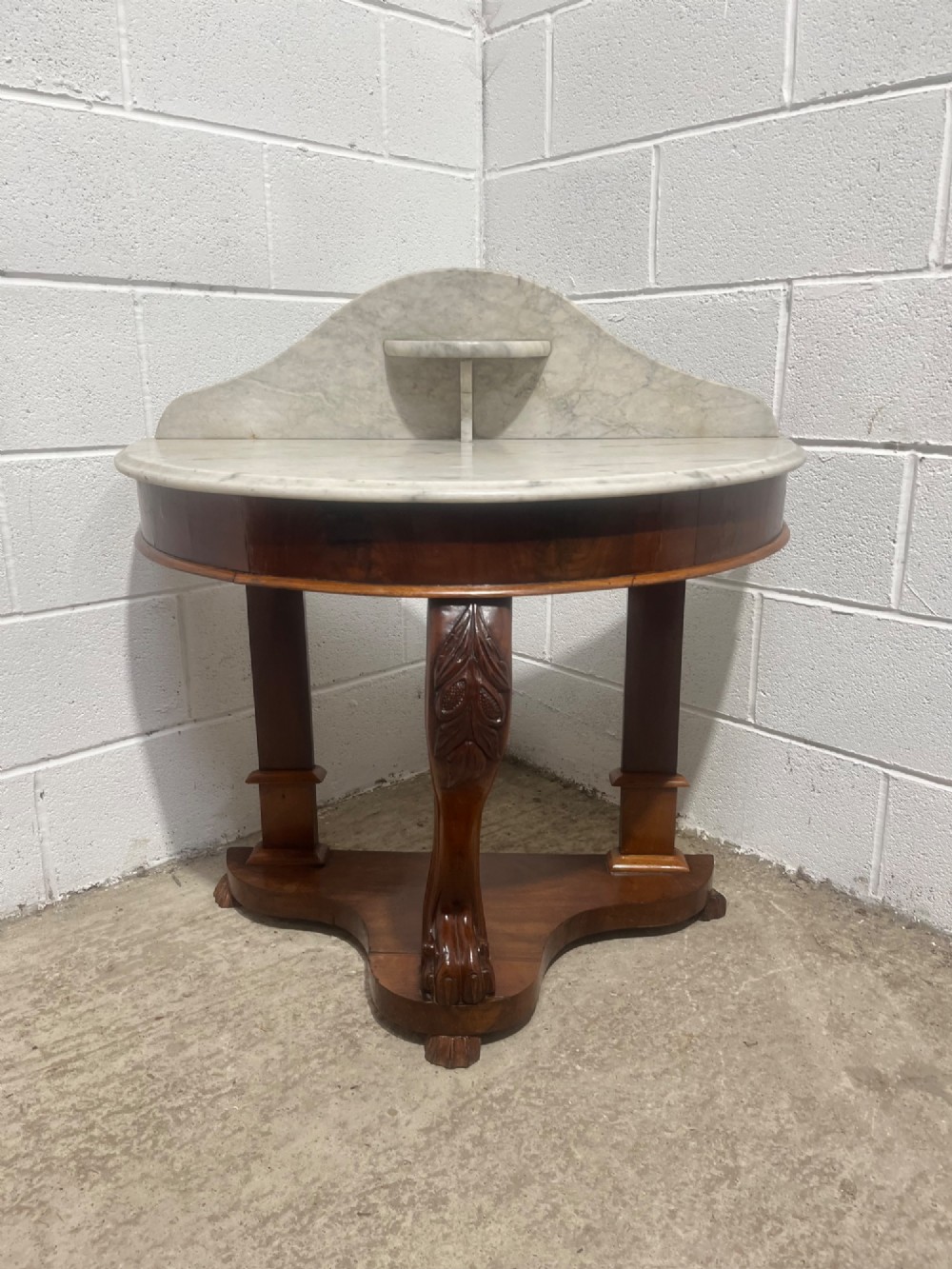 A nineteenth-century mahogany console table featuring a circular white marble top, a shaped marble splashback with an integrated shelf, and a carved central leg resting on a plinth base. View II