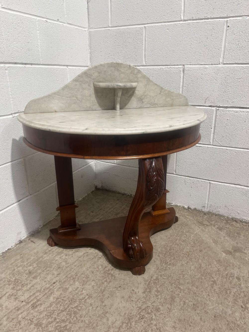 A nineteenth-century mahogany console table featuring a circular white marble top, a shaped marble splashback with an integrated shelf, and a carved central leg resting on a plinth base. View III