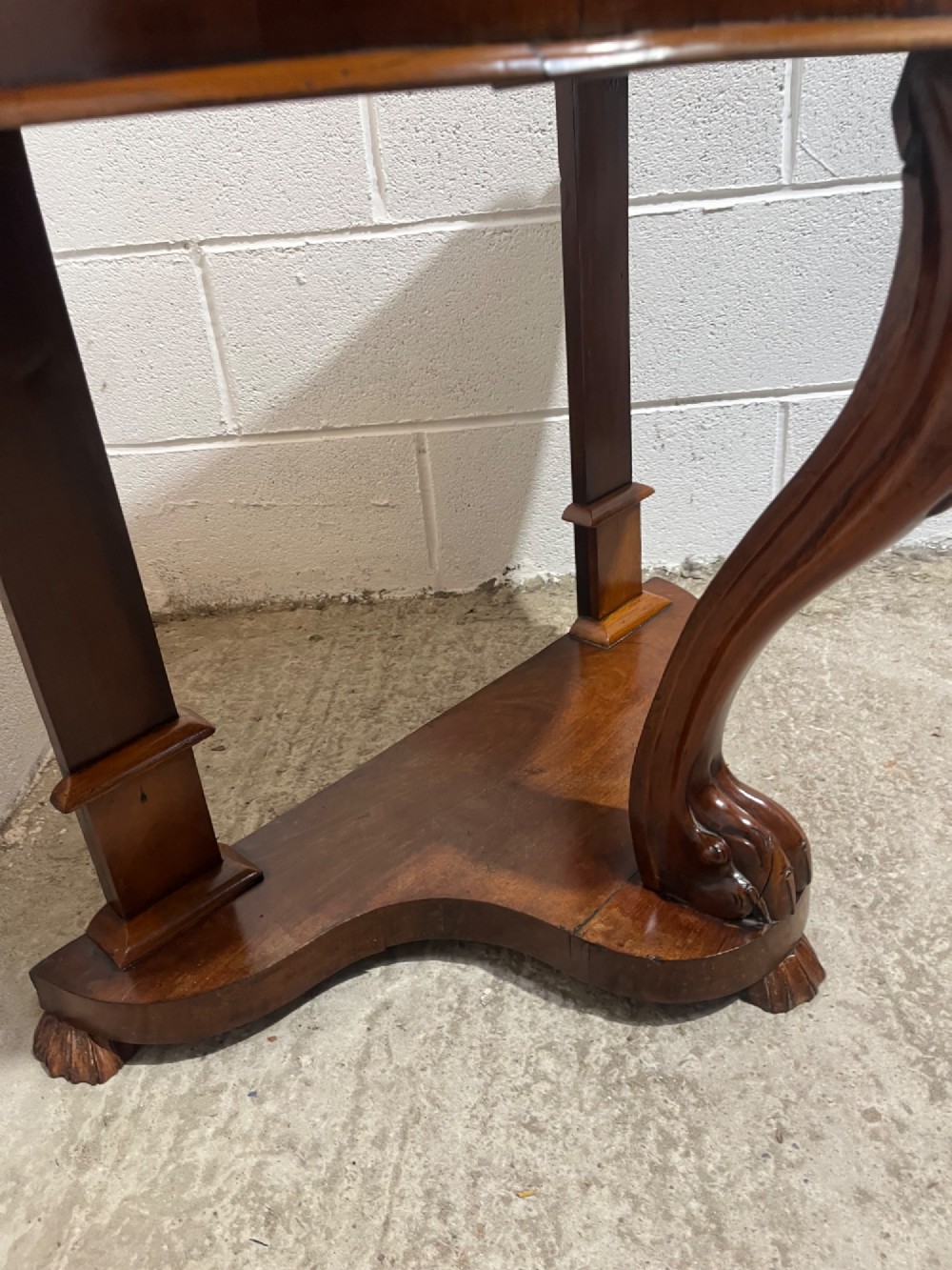 A nineteenth-century mahogany console table featuring a circular white marble top, a shaped marble splashback with an integrated shelf, and a carved central leg resting on a plinth base. View VII