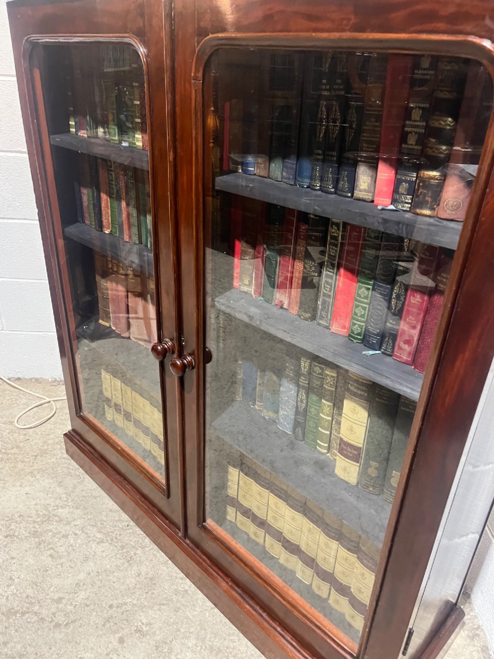 A 19th-century mahogany glazed bookcase with two glass-panelled doors revealing shelves filled with books. View VII