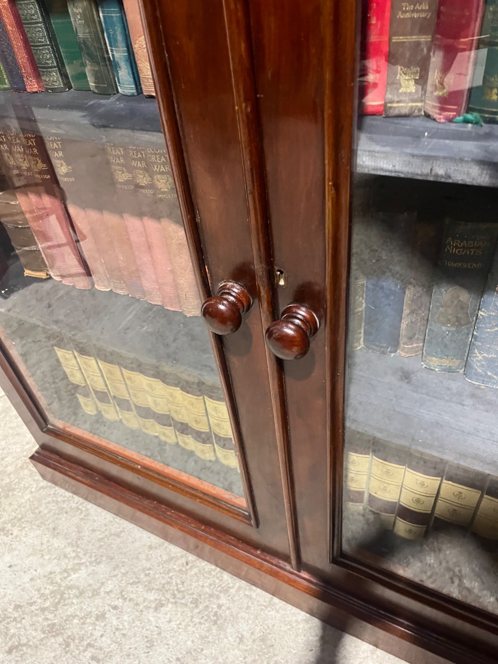 A 19th-century mahogany glazed bookcase with two glass-panelled doors revealing shelves filled with books. View IX