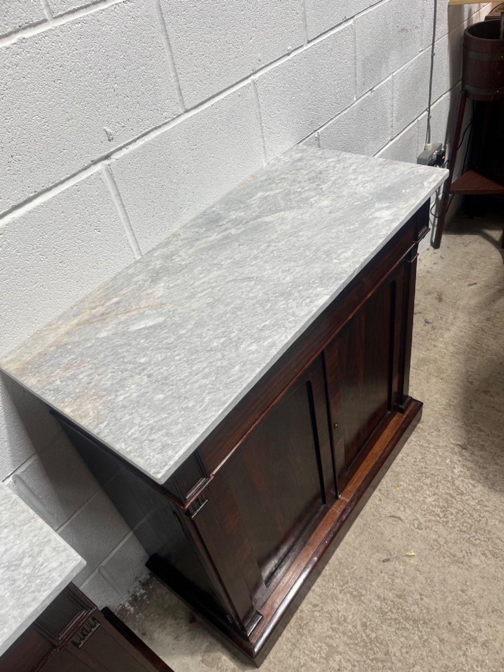 A pair of 19th-century rosewood cupboards featuring dark figured wood grain, double panelled doors, and grey marble tops. View V