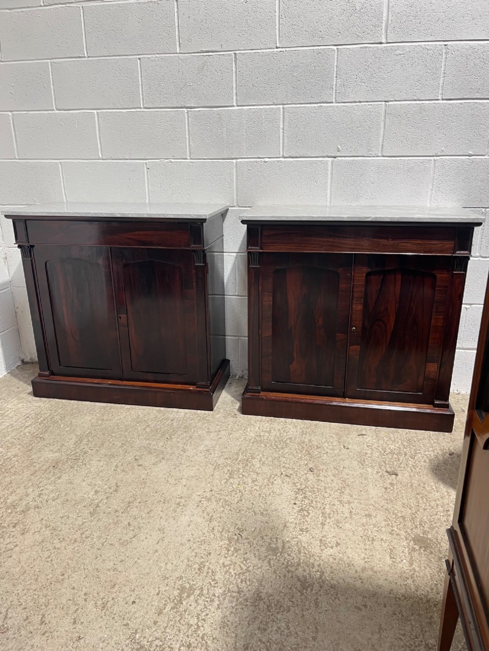 A pair of 19th-century rosewood cupboards featuring dark figured wood grain, double panelled doors, and grey marble tops. View XIV