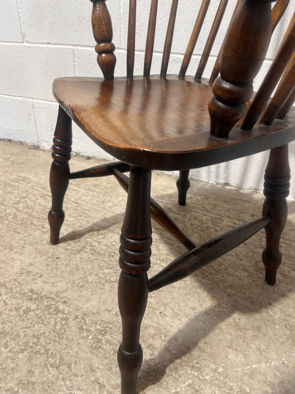 An antique 19th-century ash and elm high-back Windsor armchair featuring a hoop back with central pierced splat, turned arm supports, shaped saddle seat, and turned legs with an H-stretcher. View VII