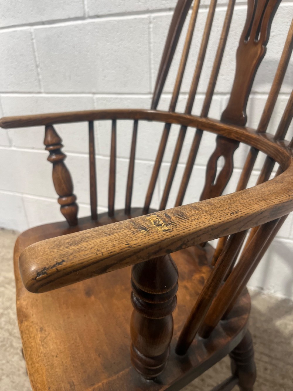 An antique 19th-century ash and elm high-back Windsor armchair featuring a hoop back with central pierced splat, turned arm supports, shaped saddle seat, and turned legs with an H-stretcher. View IX