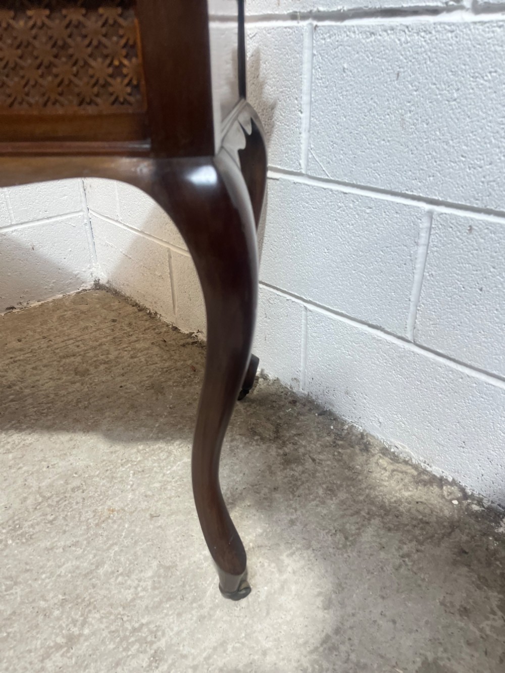 An Edwardian dark mahogany writing desk featuring two blind fretwork carved drawers with brass drop handles and slender cabriole legs on brass castors. View VIII