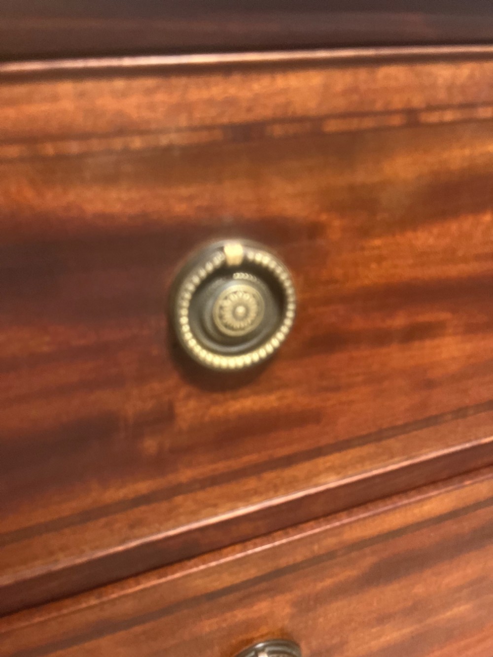 A nineteenth-century mahogany chest of three full-width drawers featuring brass ring handles, boxwood string inlay, and splayed bracket feet. View VII