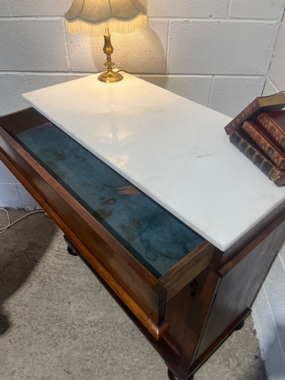 A 19th-century mahogany cupboard featuring twin arched panel doors, flattened bun feet, and a fitted white marble top. View VIII