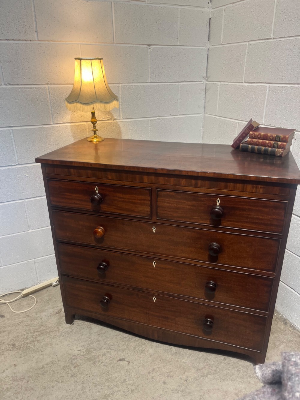A 19th-century mahogany chest of drawers featuring two short drawers over three long drawers with turned handles and diamond escutcheons. View IV