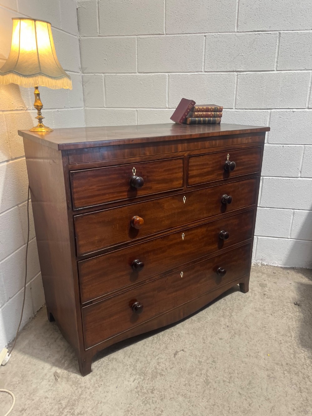 A 19th-century mahogany chest of drawers featuring two short drawers over three long drawers with turned handles and diamond escutcheons. View V