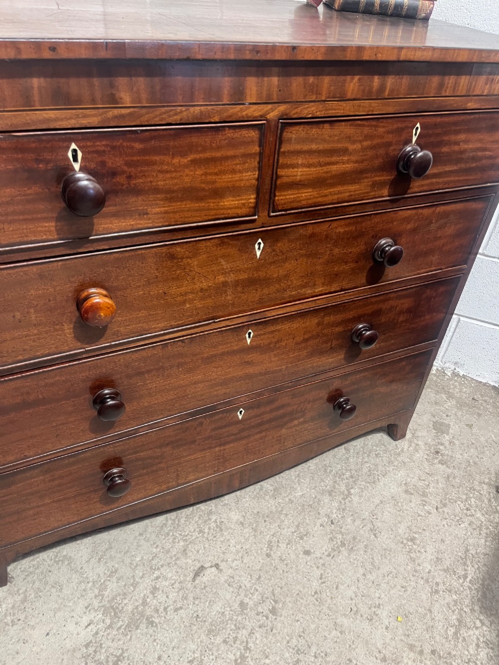 A 19th-century mahogany chest of drawers featuring two short drawers over three long drawers with turned handles and diamond escutcheons. View VII