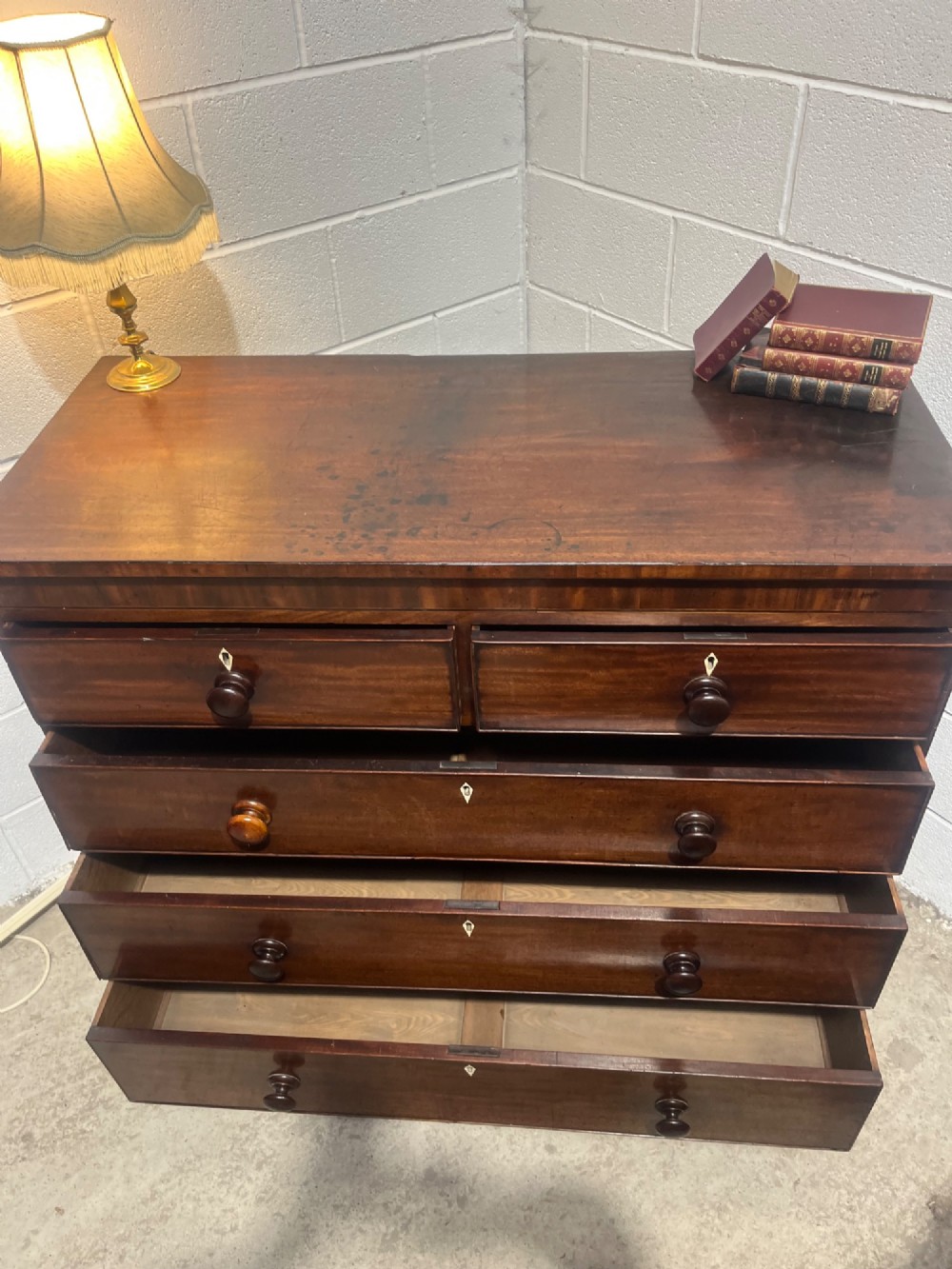 A 19th-century mahogany chest of drawers featuring two short drawers over three long drawers with turned handles and diamond escutcheons. View VIII