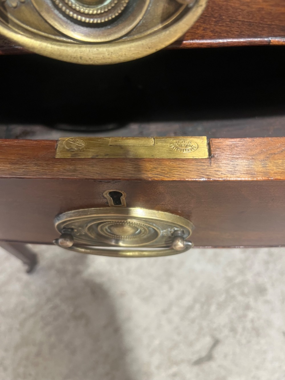 A Georgian mahogany bowfront hall table featuring four drawers with brass handles and tapered square legs on brass castors. View XI