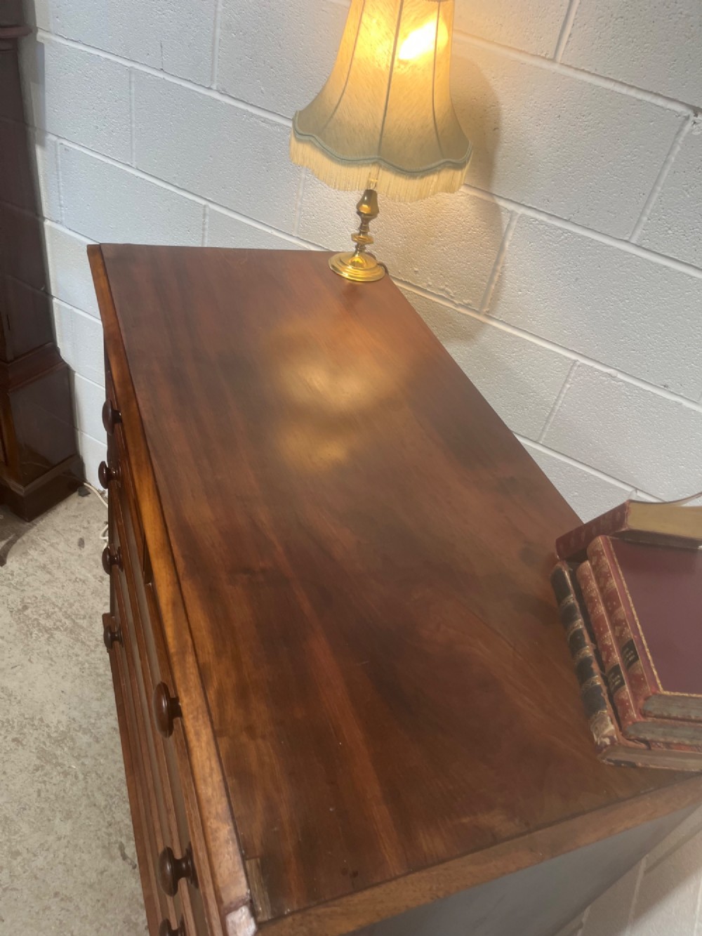 A 19th-century mahogany chest of drawers with a two-over-three drawer configuration, turned wooden knobs, and turned bun feet. View V