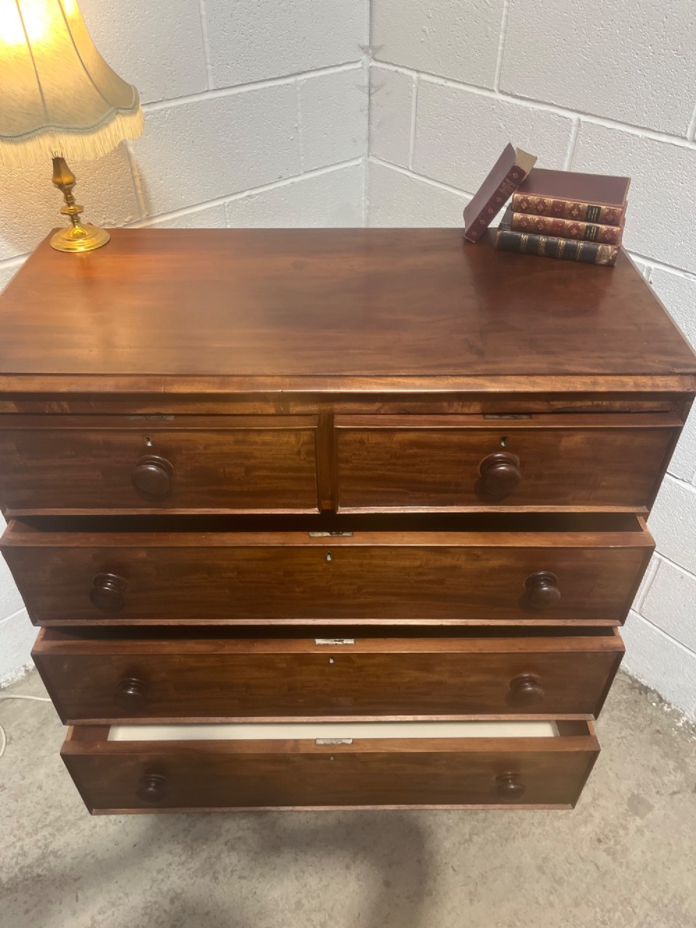 A 19th-century mahogany chest of drawers with a two-over-three drawer configuration, turned wooden knobs, and turned bun feet. View VII