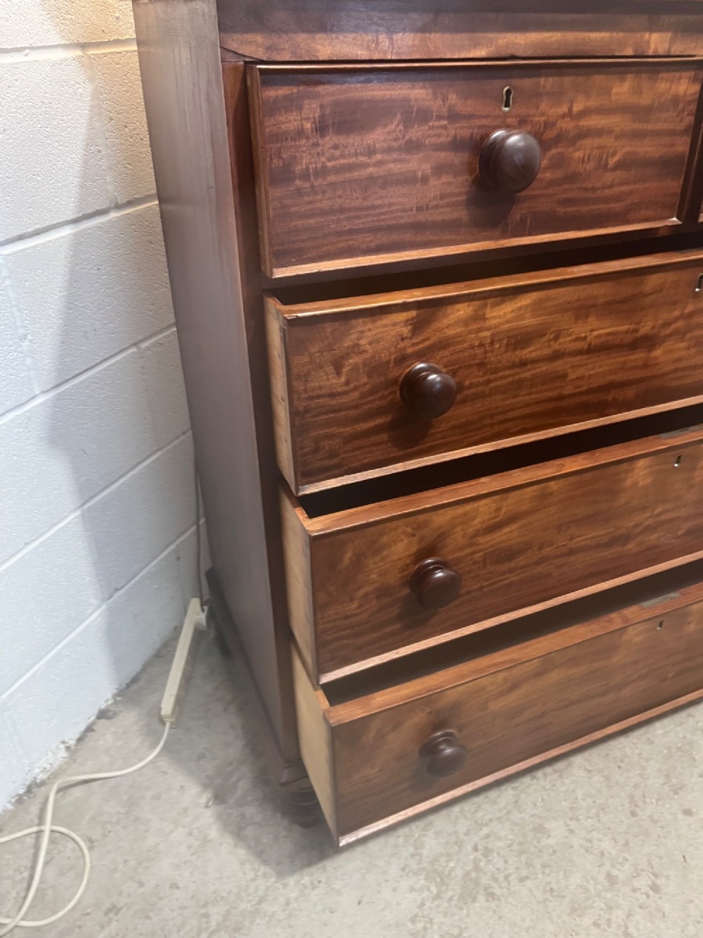 A 19th-century mahogany chest of drawers with a two-over-three drawer configuration, turned wooden knobs, and turned bun feet. View VIII