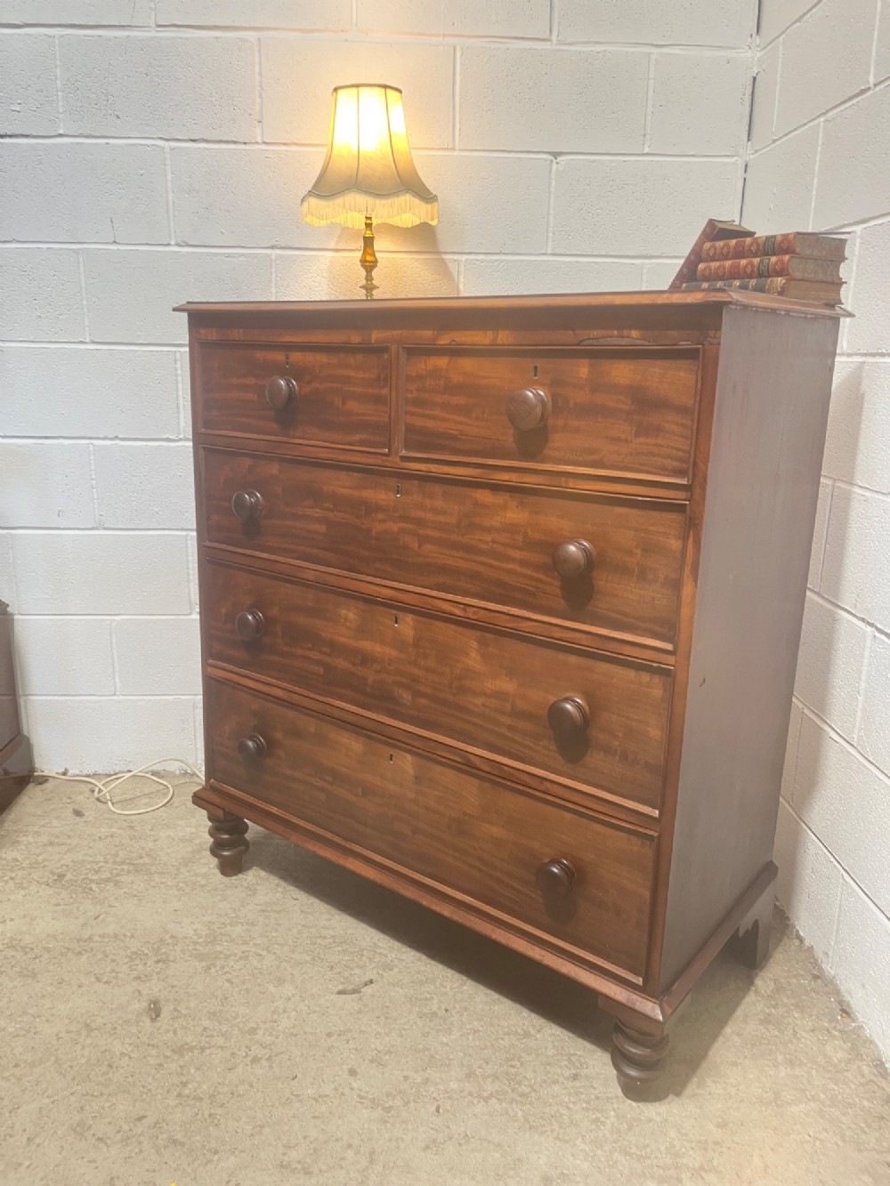 A 19th-century mahogany chest of drawers with a two-over-three drawer configuration, turned wooden knobs, and turned bun feet. View X