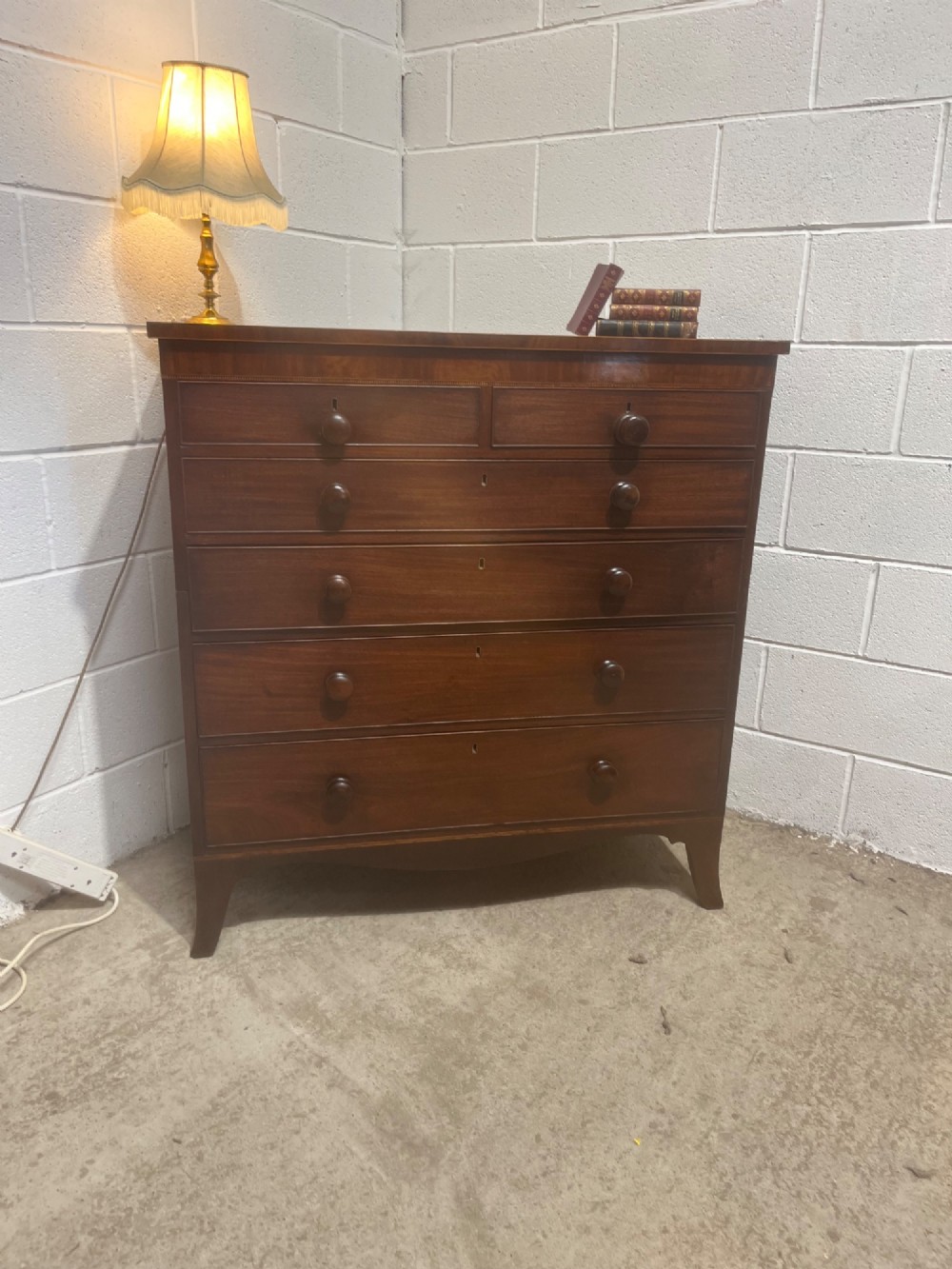 A nineteenth-century mahogany chest of drawers featuring five heights of drawers, turned wooden handles, and splayed feet. View II