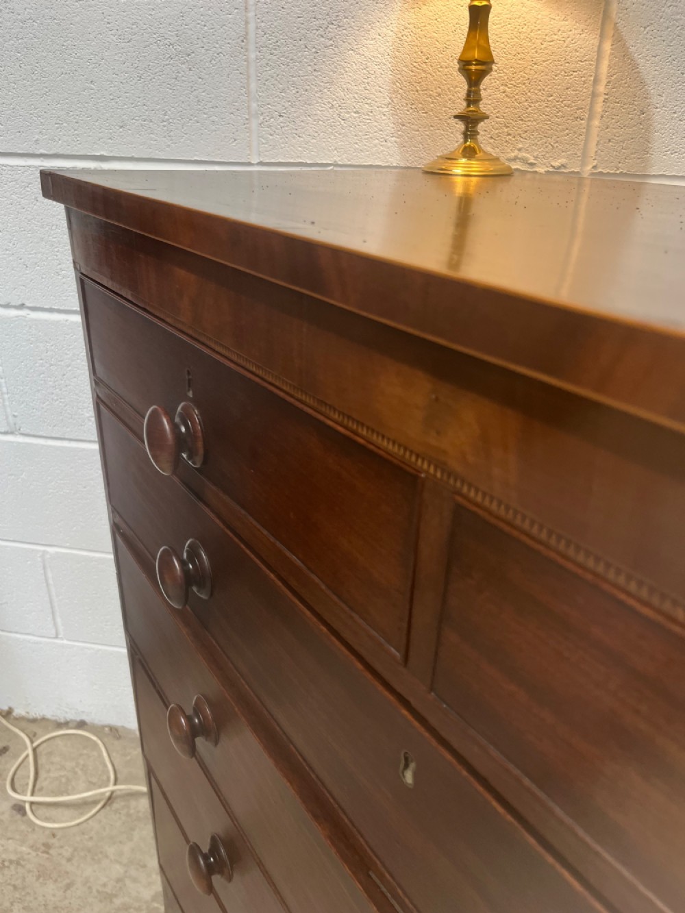 A nineteenth-century mahogany chest of drawers featuring five heights of drawers, turned wooden handles, and splayed feet. View V