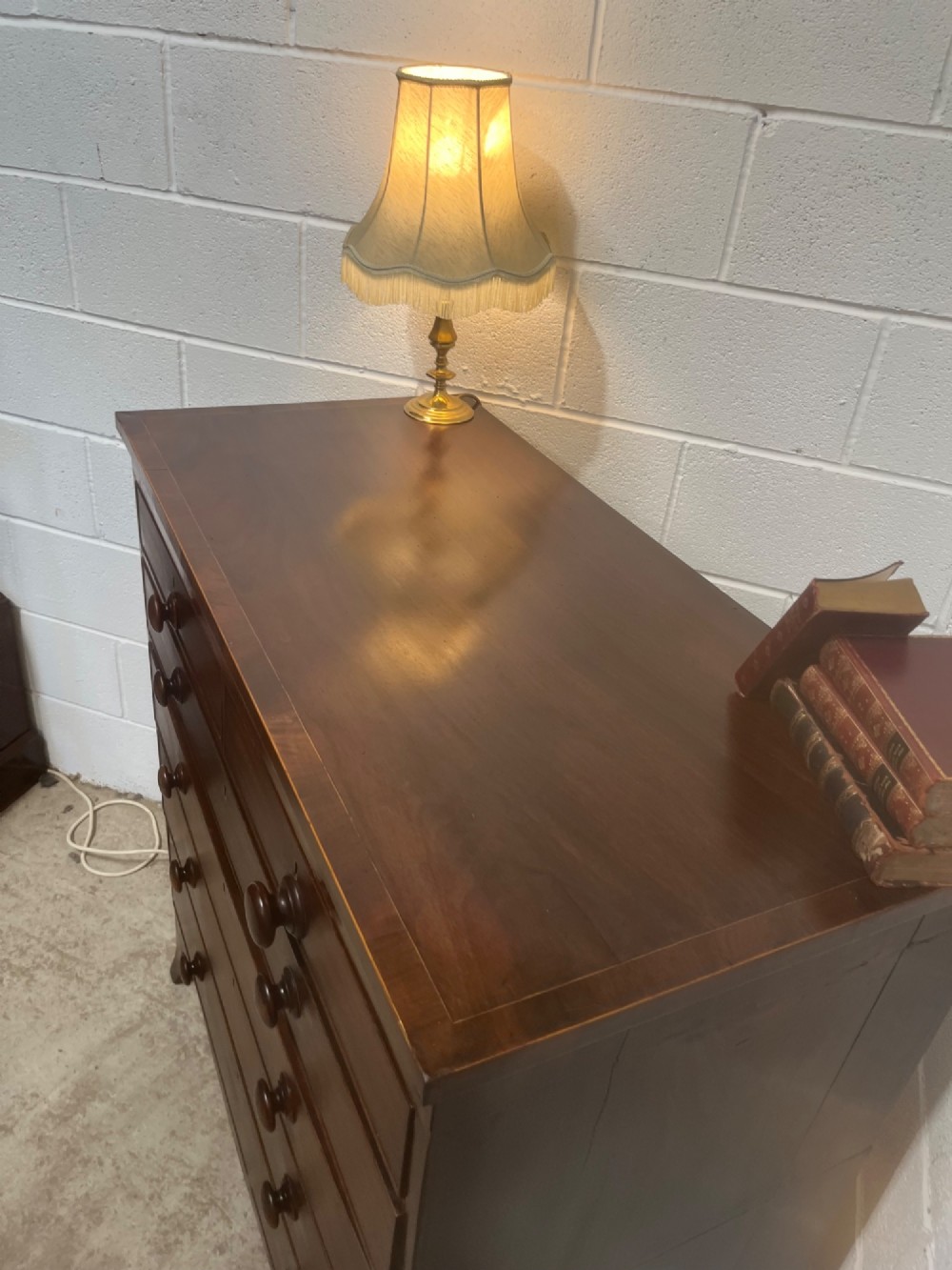 A nineteenth-century mahogany chest of drawers featuring five heights of drawers, turned wooden handles, and splayed feet. View VI