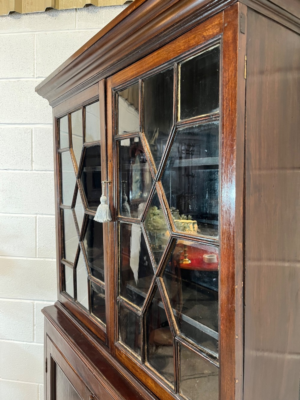 A tall 19th-century mahogany bookcase featuring upper astragal glazed doors above a lower two-door solid panelled cupboard. View V