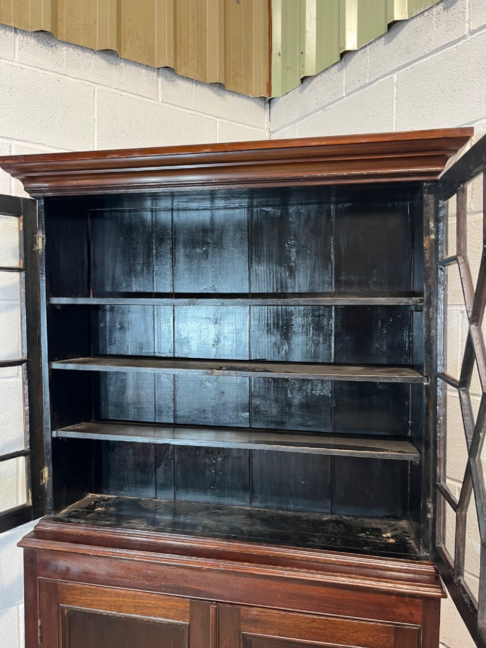A tall 19th-century mahogany bookcase featuring upper astragal glazed doors above a lower two-door solid panelled cupboard. View VIII