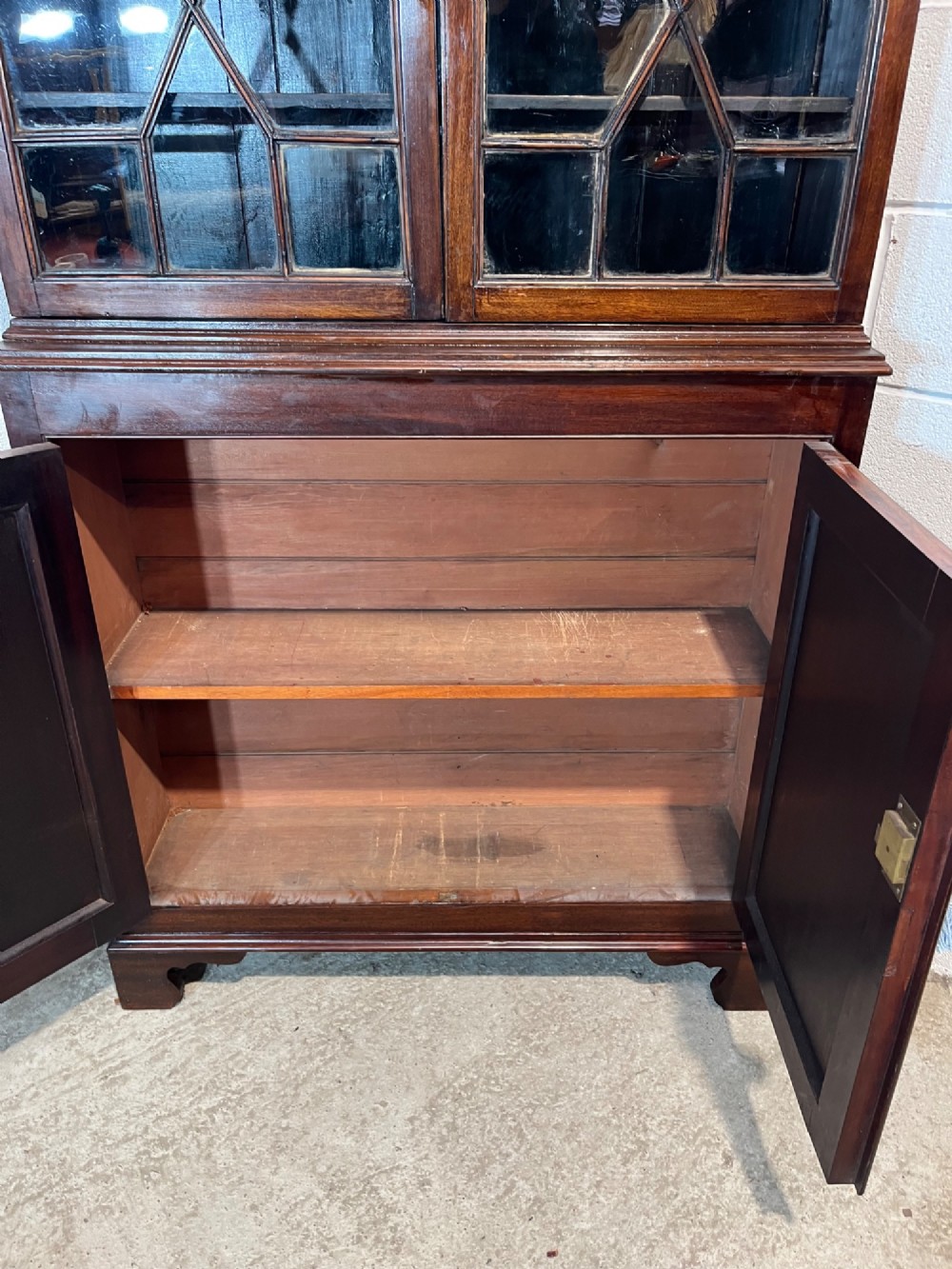 A tall 19th-century mahogany bookcase featuring upper astragal glazed doors above a lower two-door solid panelled cupboard. View IX