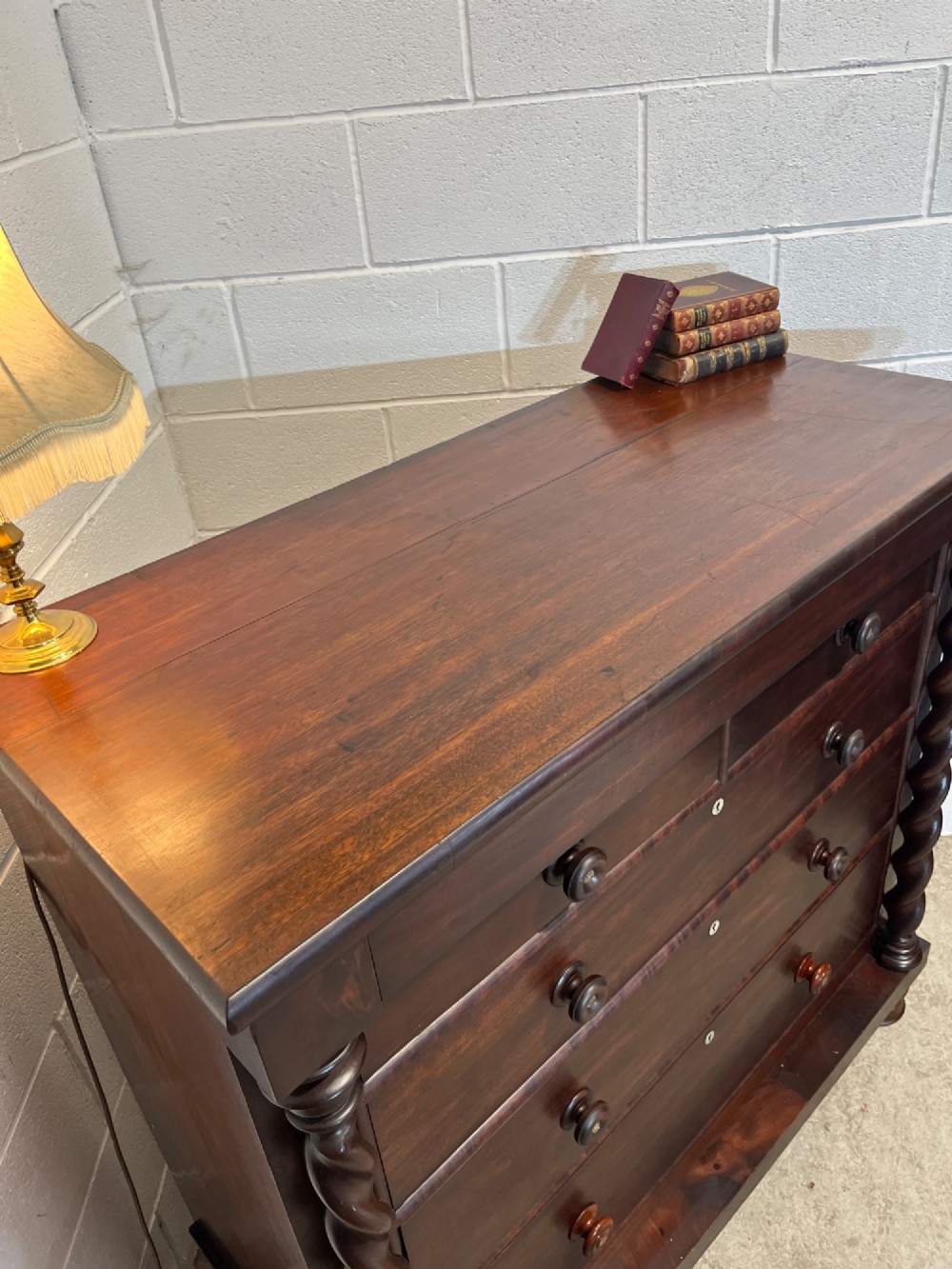 A 19th-century dark mahogany Scotch chest of drawers featuring spiral barley twist side columns, turned wooden knobs, and a heavy plinth base. View VI