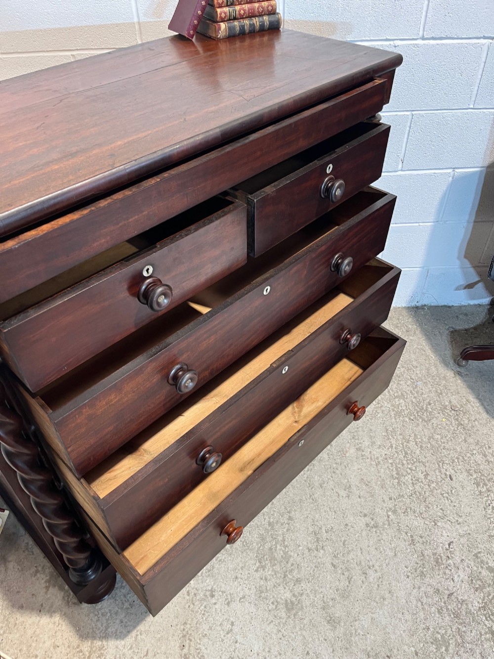 A 19th-century dark mahogany Scotch chest of drawers featuring spiral barley twist side columns, turned wooden knobs, and a heavy plinth base. View IX