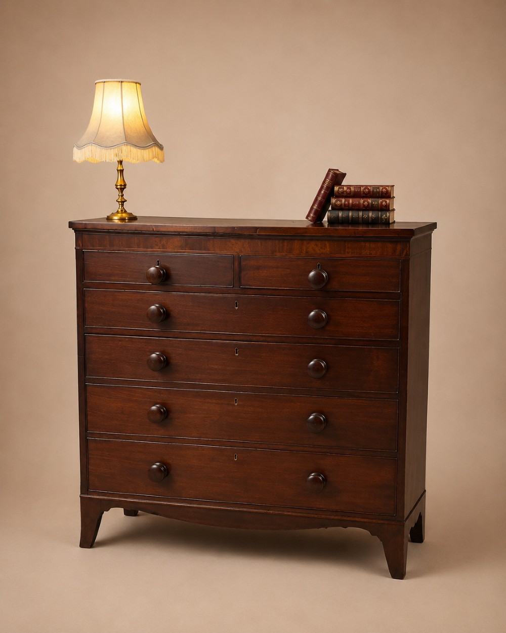 A nineteenth-century mahogany chest of drawers featuring five heights of drawers, turned wooden handles, and splayed feet.