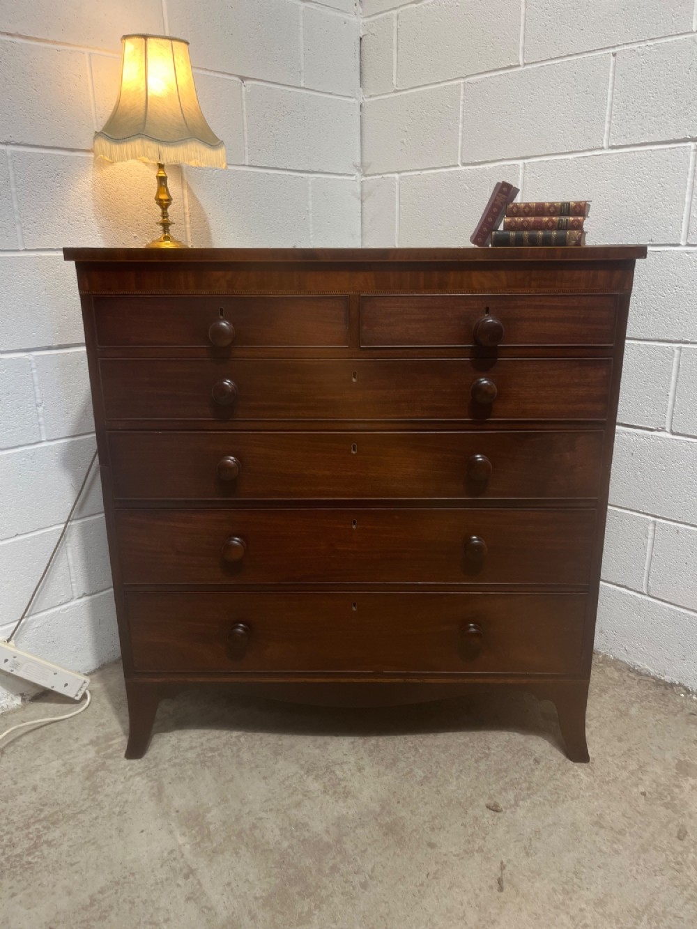 A nineteenth-century mahogany chest of drawers featuring five heights of drawers, turned wooden handles, and splayed feet. View III