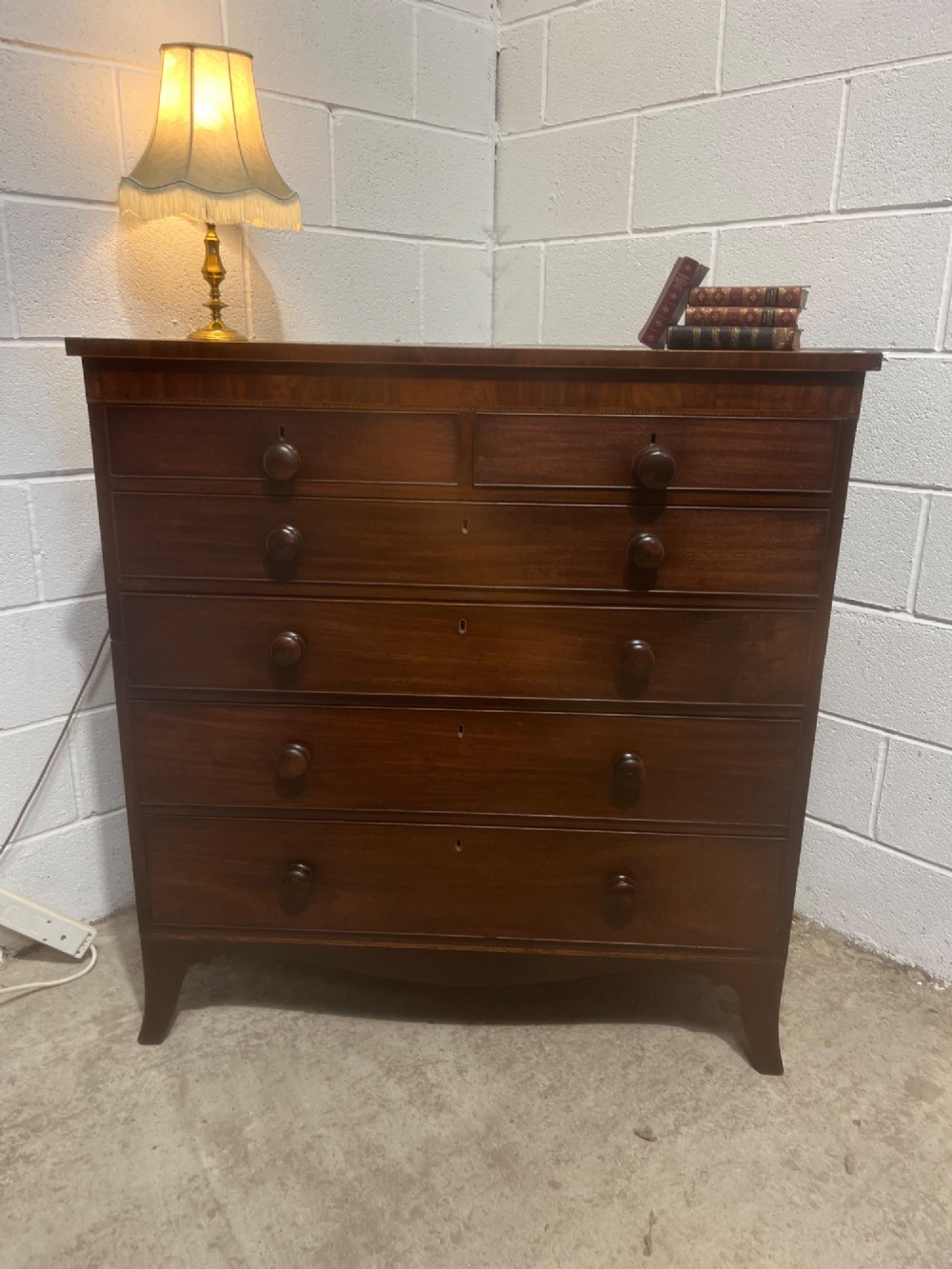 A nineteenth-century mahogany chest of drawers featuring five heights of drawers, turned wooden handles, and splayed feet. View VIII