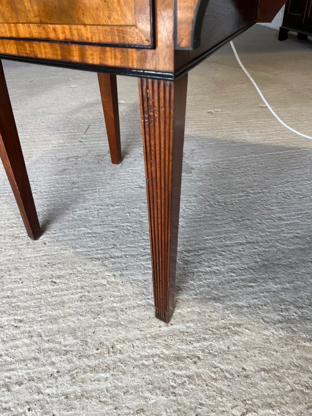 A Georgian mahogany sideboard featuring flame mahogany drawer fronts, brass ring handles, decorative line inlay, and fluted tapered legs. View VIII