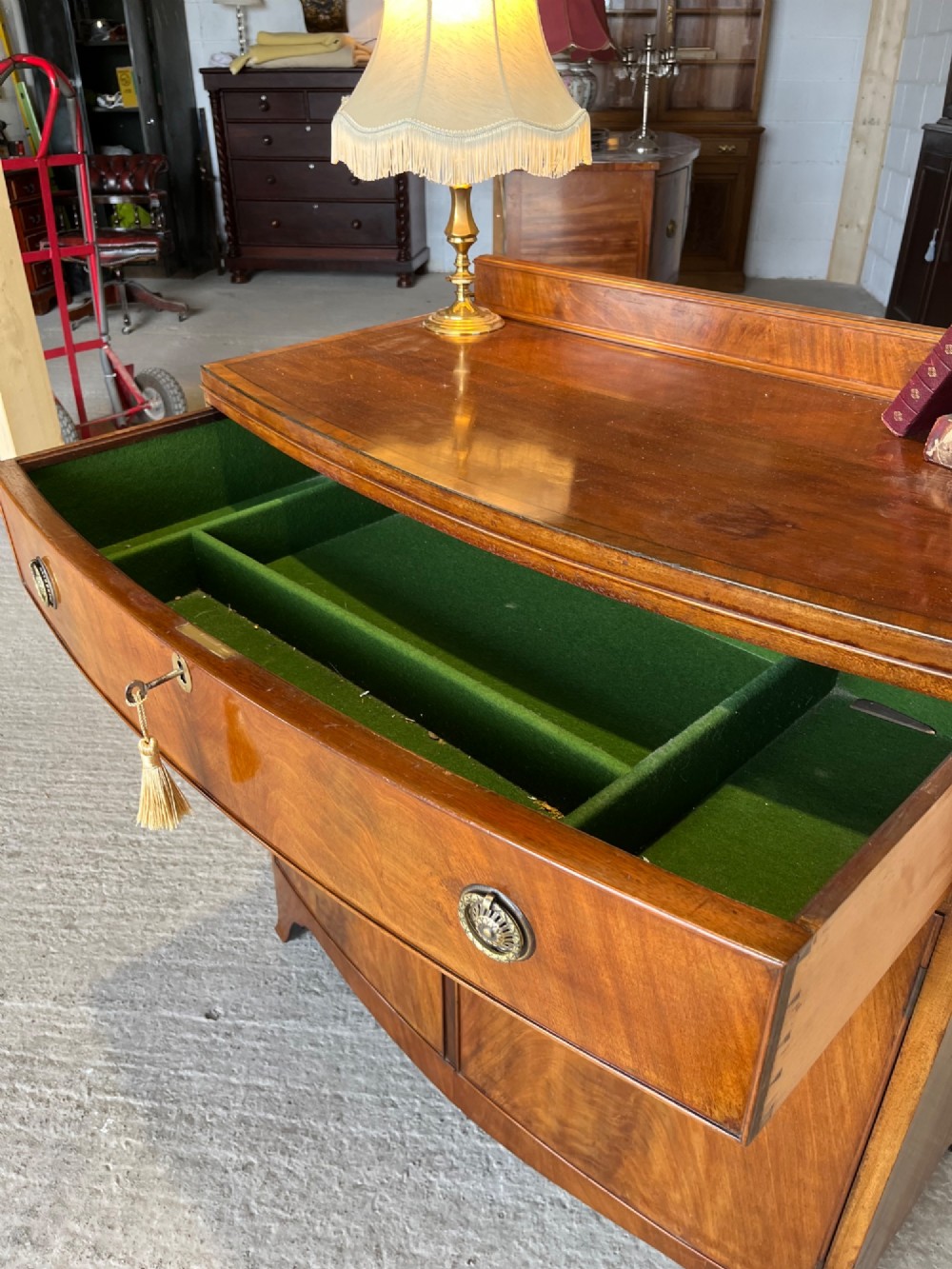 A late 19th-century mahogany cupboard featuring a single top drawer over a two-door cabinet with flame mahogany veneer panels and turned brass ring pull handles. View VI