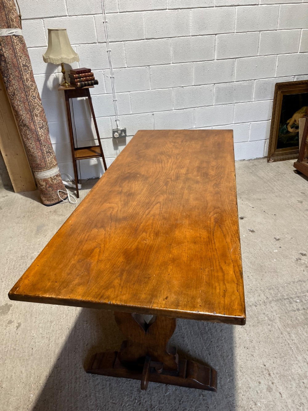 A long solid oak refectory table with a trestle base, surrounded by eight ladderback dining chairs with woven rush seats. View VIII