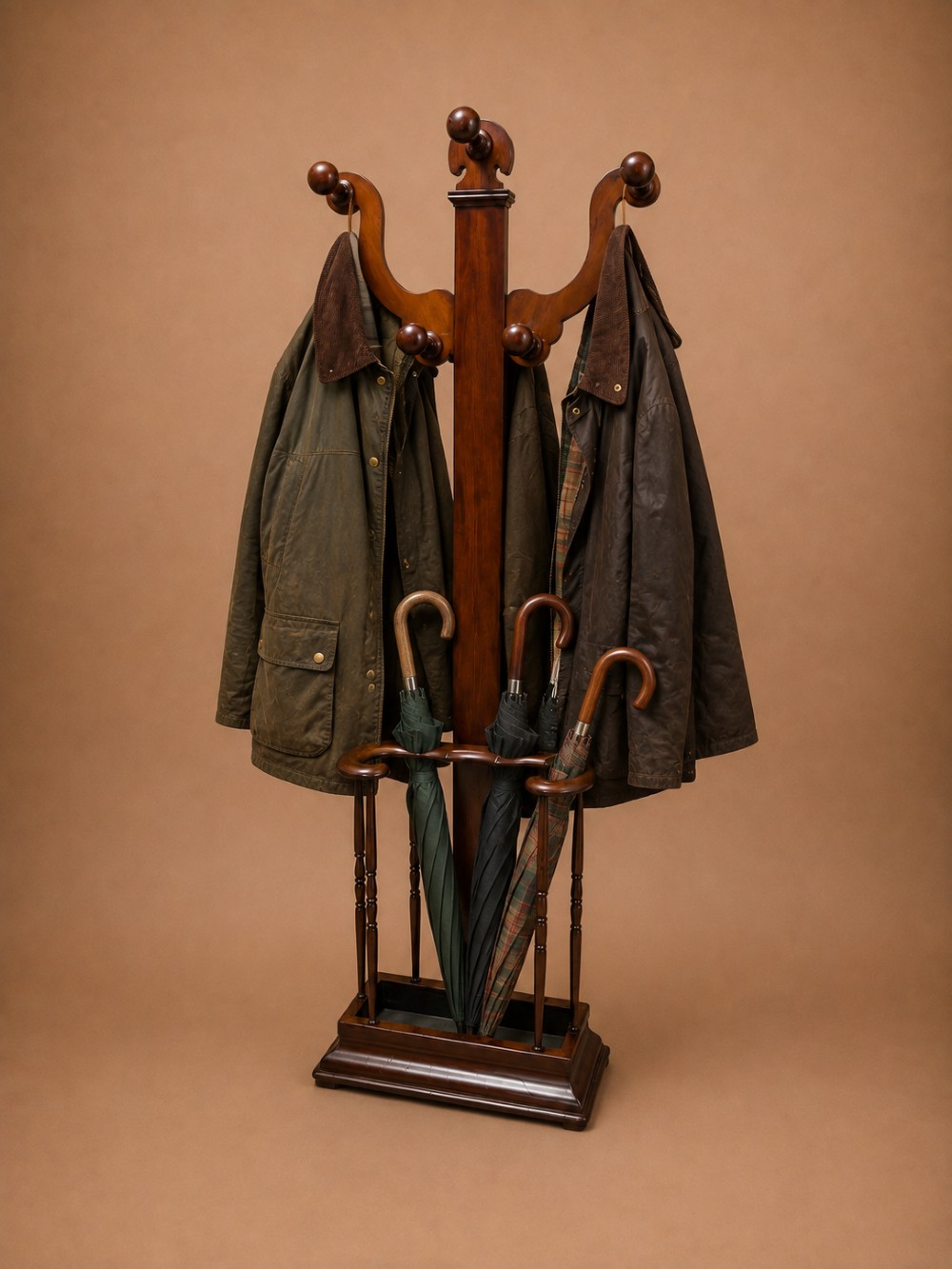 A 19th-century mahogany freestanding hall stand featuring turned wooden pegs on curved scroll arms above a lower umbrella holder with a drip tray. View II