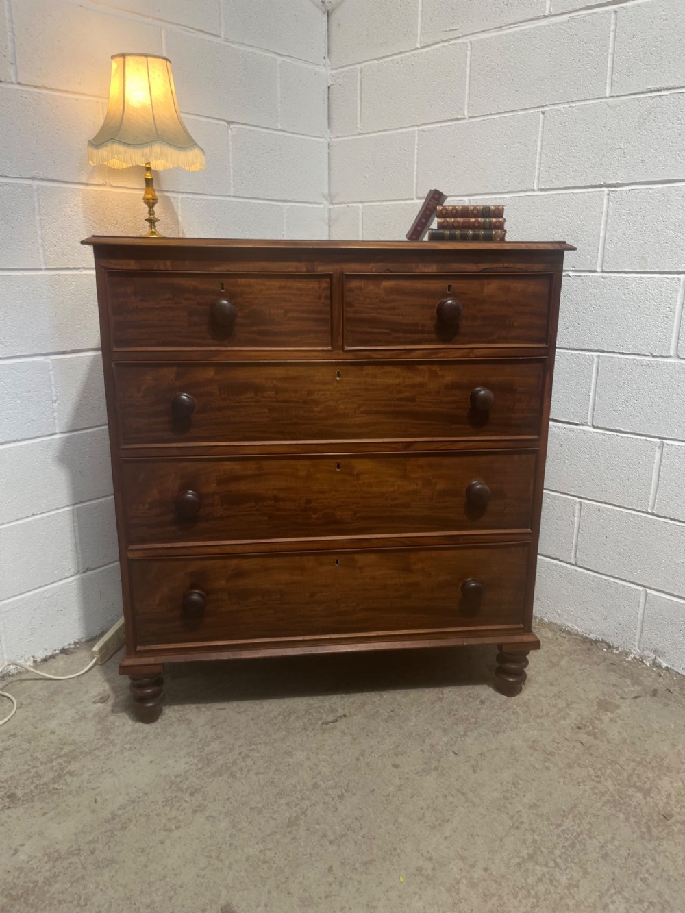 A 19th-century mahogany chest of drawers with a two-over-three drawer configuration, turned wooden knobs, and turned bun feet. View II