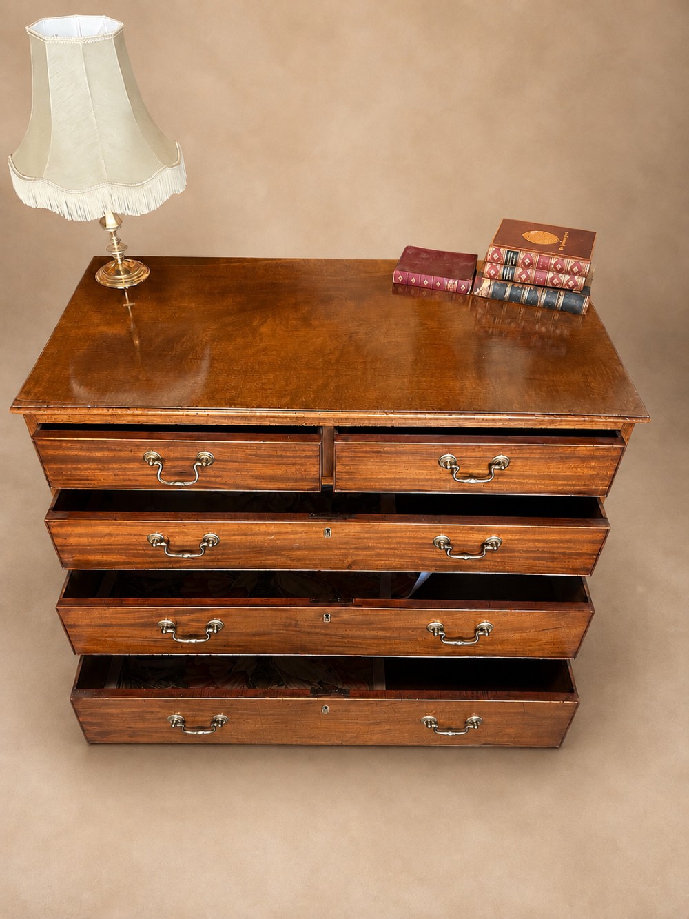 A Georgian mahogany chest of drawers featuring two short over three long graduated drawers with brass swan-neck handles and bracket feet. View VIII