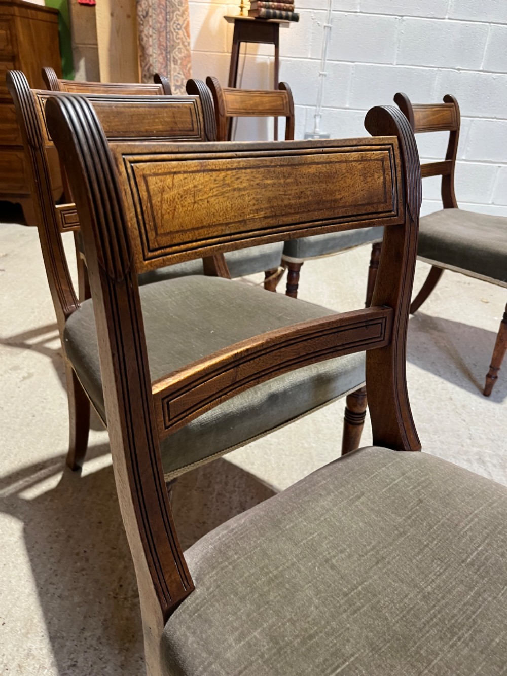 Set of six Regency mahogany dining chairs featuring horizontal bar backrests, green velvet seats, turned front legs, and splayed rear legs. View VII