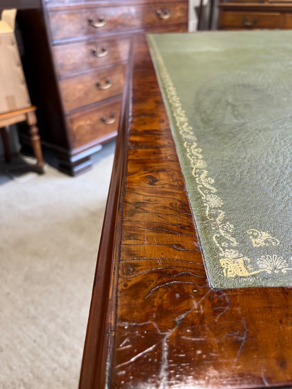 A nineteenth-century Victorian burr walnut pedestal desk featuring a green leather writing surface, multiple drawers with turned wooden handles, and a plinth base. View XI