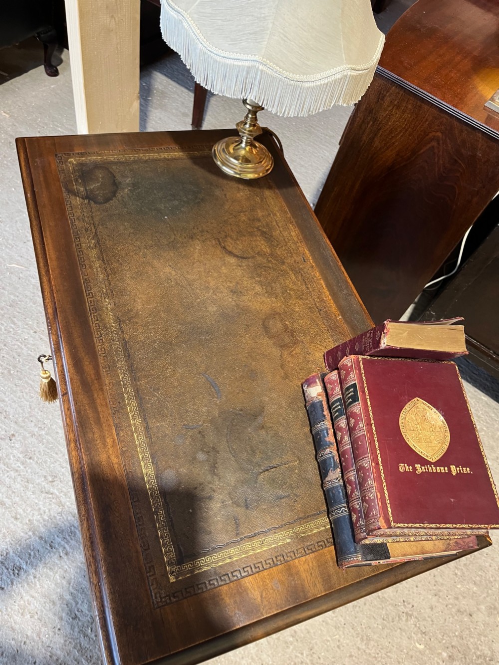 A late 19th-century dark mahogany kneehole desk featuring nine drawers with decorative brass handles and a central kneehole recess. View VII