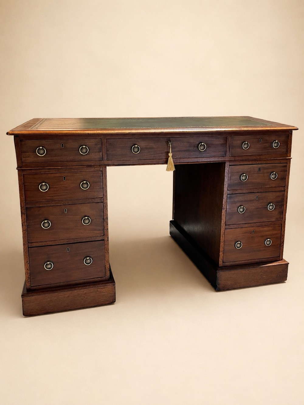 A 19th-century mahogany pedestal desk featuring an inset green leather top, brass ring pull handles, and nine drawers over plinth bases. View II