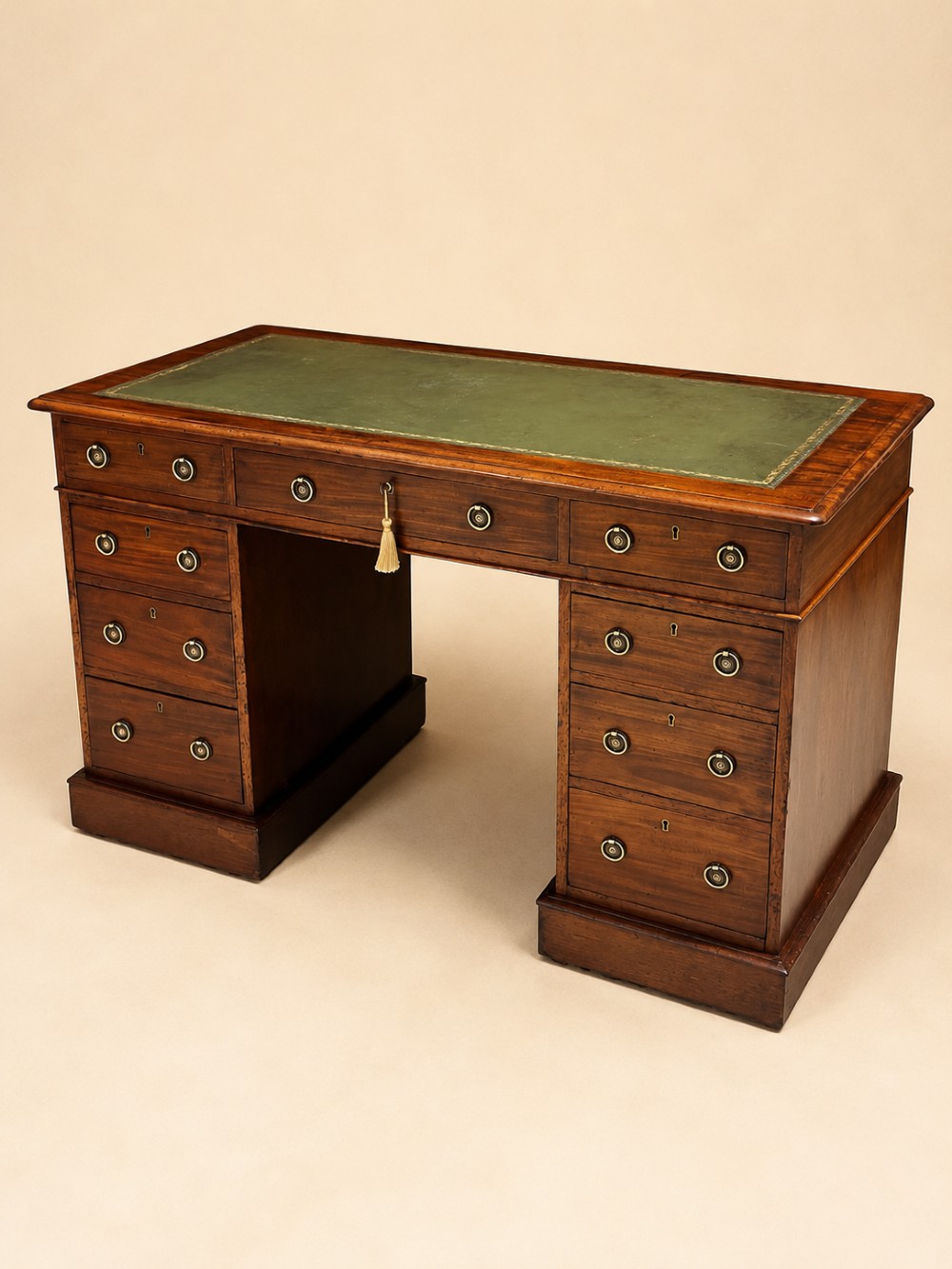 A 19th-century mahogany pedestal desk featuring an inset green leather top, brass ring pull handles, and nine drawers over plinth bases. View V