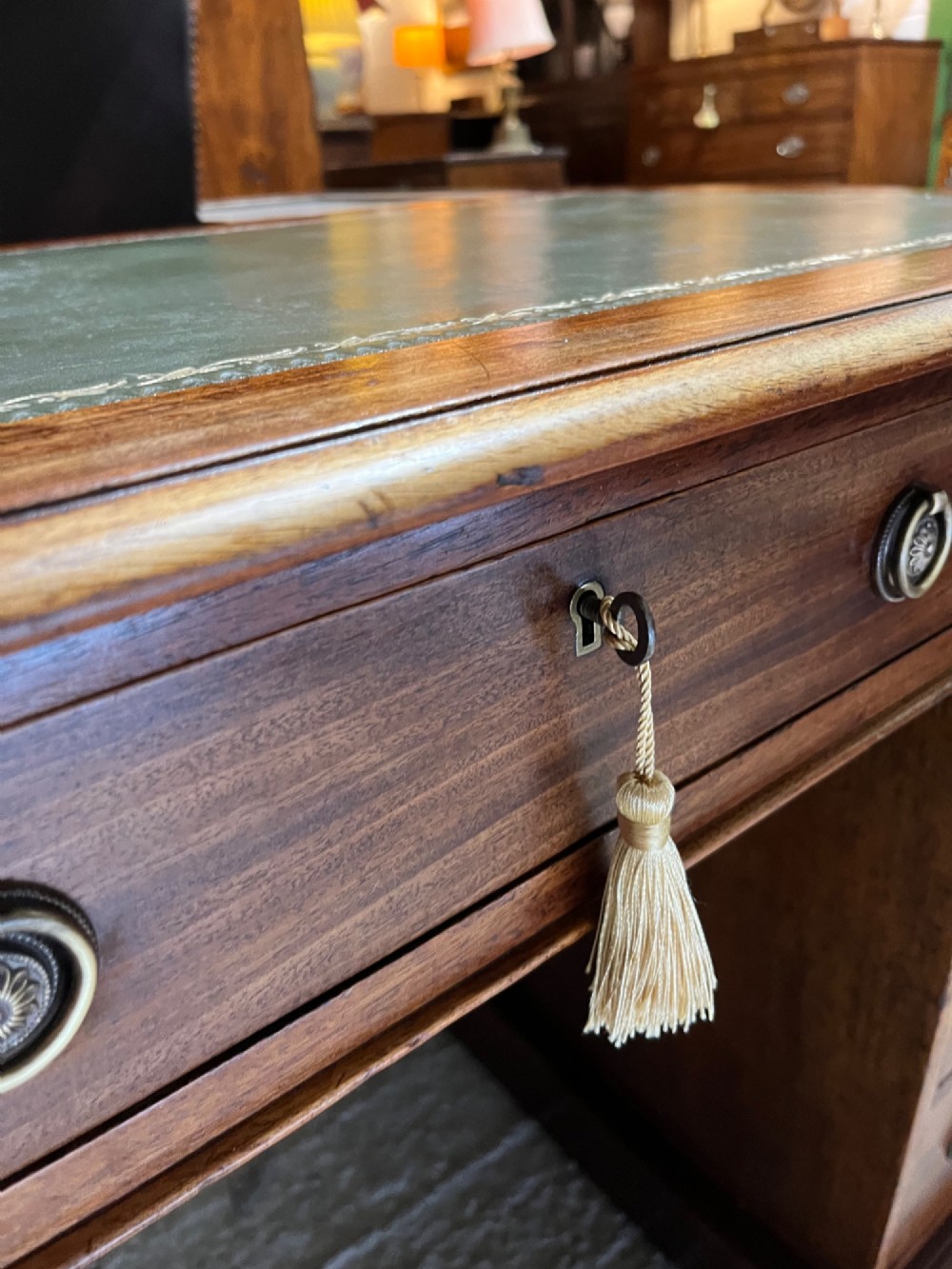 A 19th-century mahogany pedestal desk featuring an inset green leather top, brass ring pull handles, and nine drawers over plinth bases. View VI