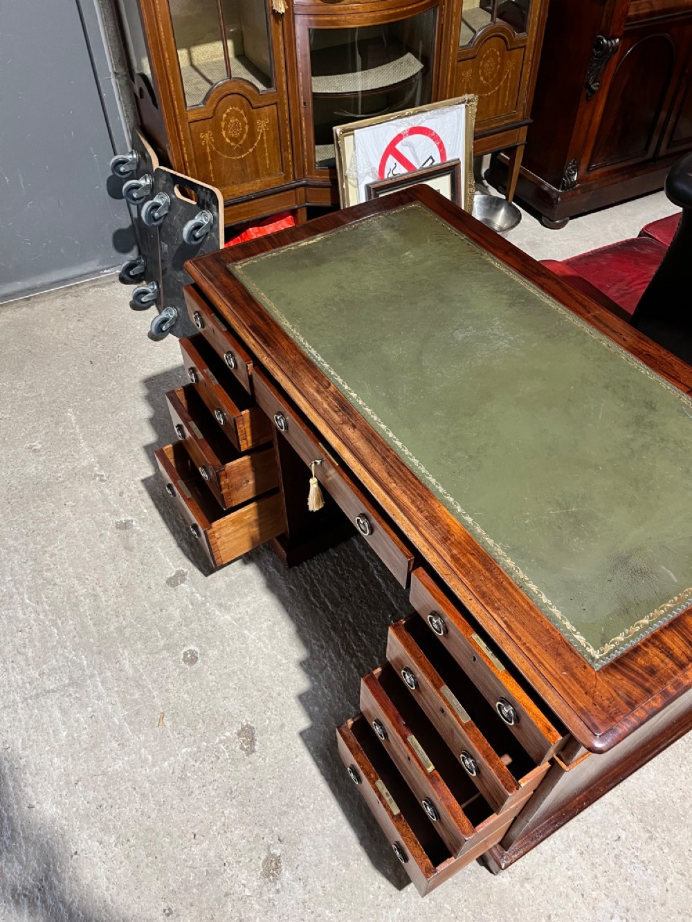 A 19th-century mahogany pedestal desk featuring an inset green leather top, brass ring pull handles, and nine drawers over plinth bases. View VIII