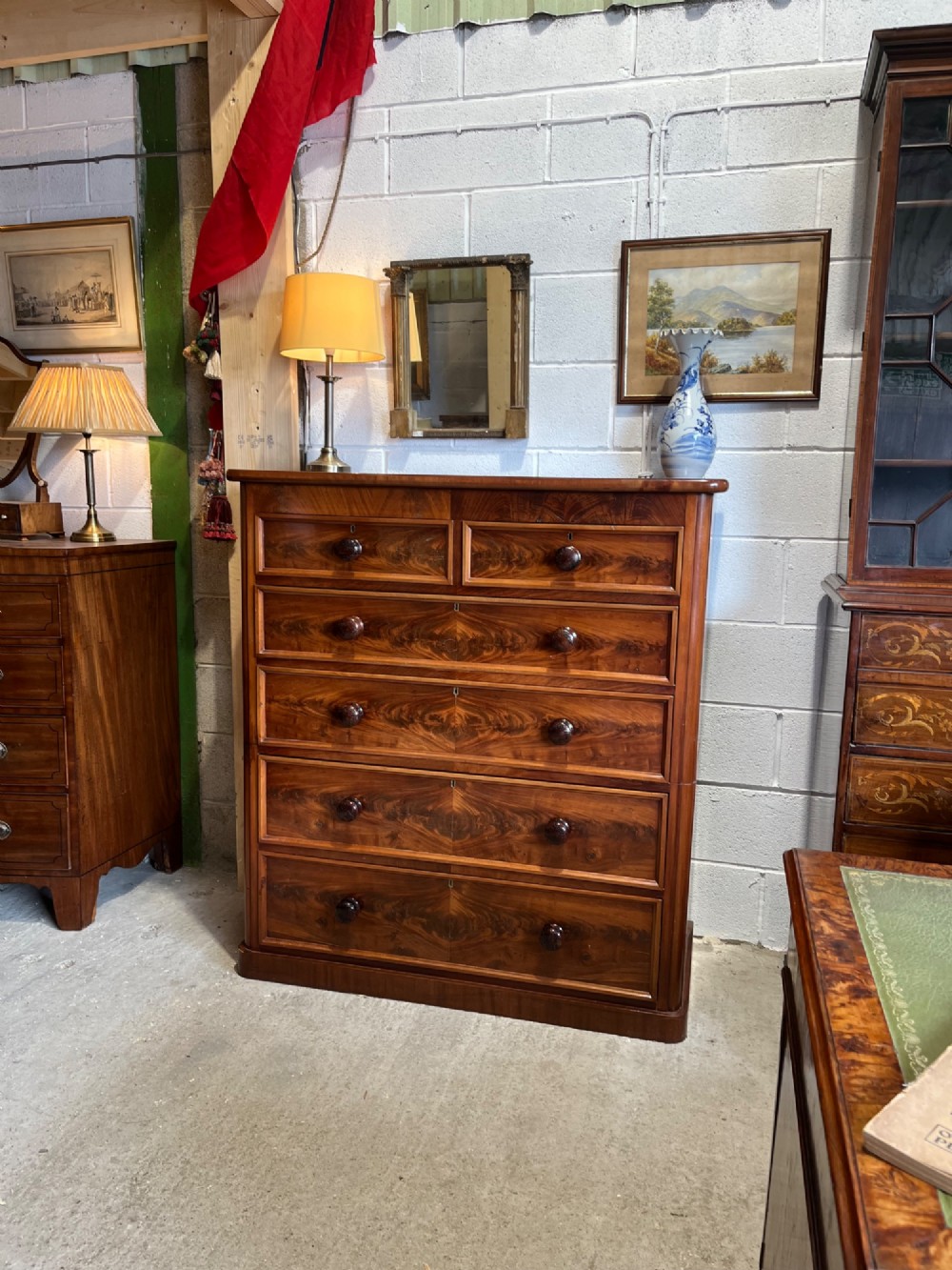 A tall nineteenth-century mahogany chest of drawers featuring two short top drawers above four long drawers with turned wooden handles on a solid plinth base. View II