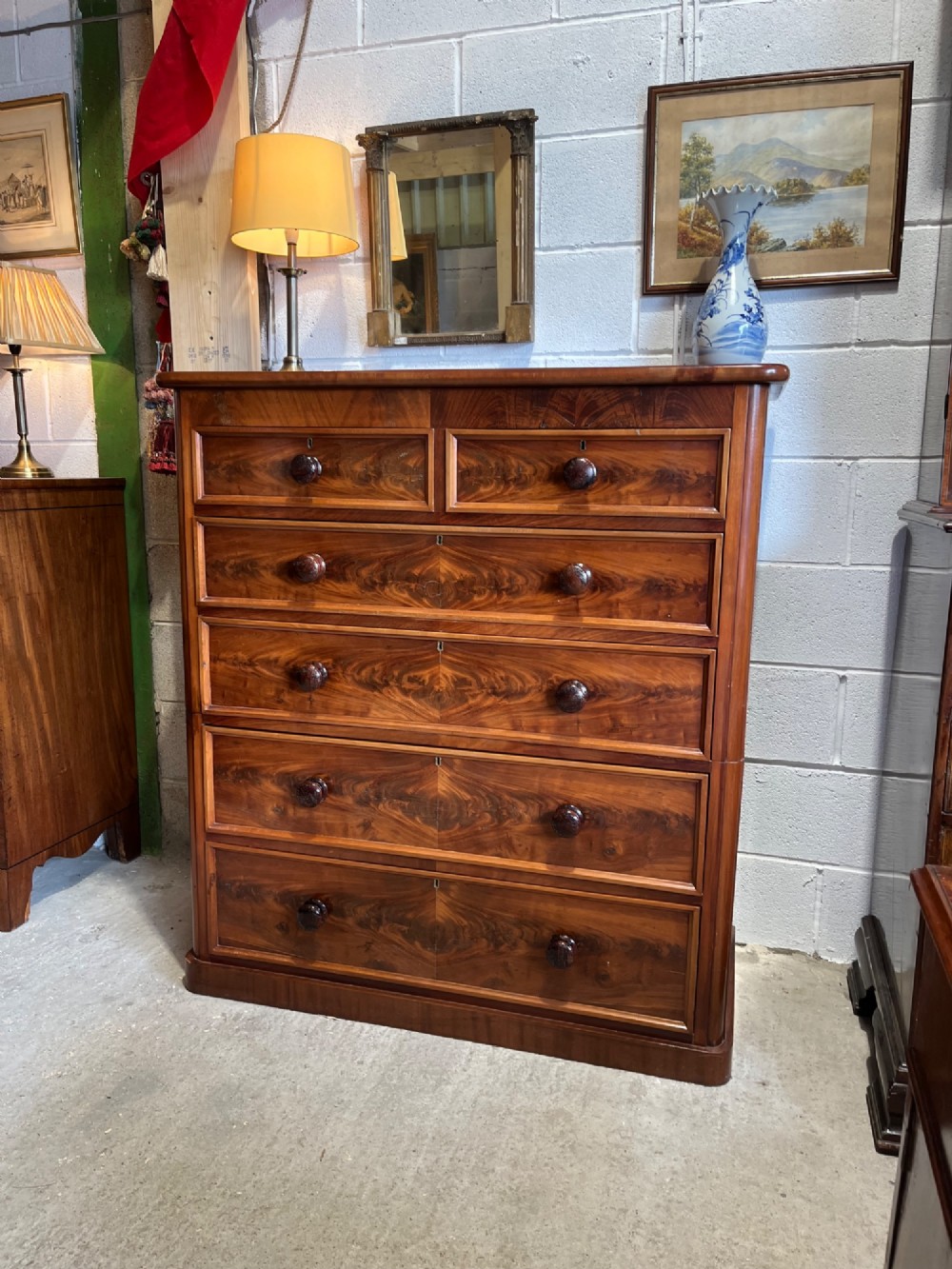 A tall nineteenth-century mahogany chest of drawers featuring two short top drawers above four long drawers with turned wooden handles on a solid plinth base. View III