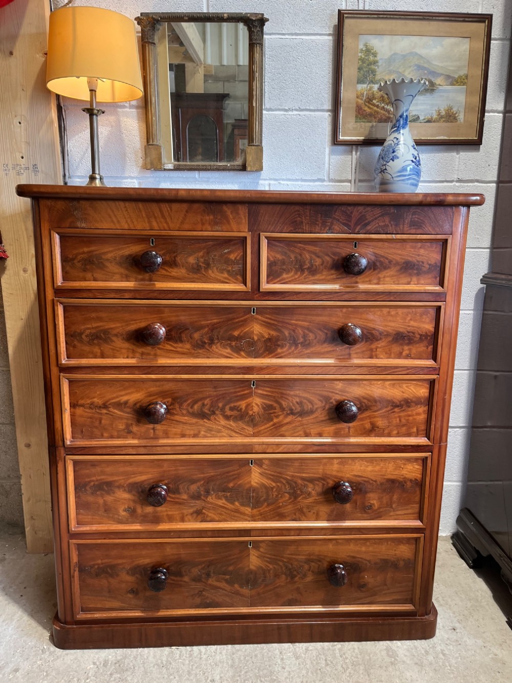 A tall nineteenth-century mahogany chest of drawers featuring two short top drawers above four long drawers with turned wooden handles on a solid plinth base. View IV