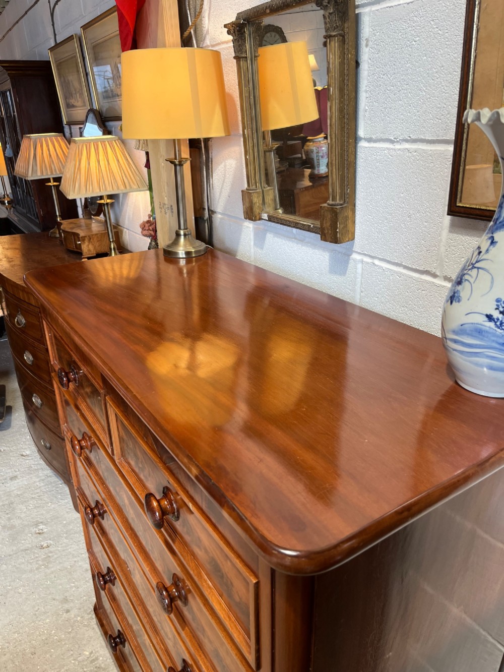 A tall nineteenth-century mahogany chest of drawers featuring two short top drawers above four long drawers with turned wooden handles on a solid plinth base. View VI