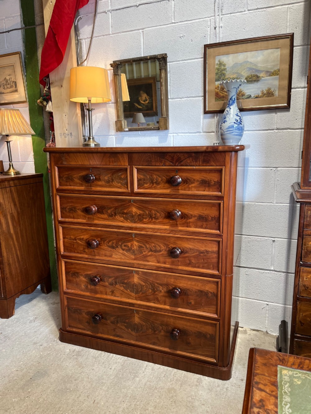 A tall nineteenth-century mahogany chest of drawers featuring two short top drawers above four long drawers with turned wooden handles on a solid plinth base. View VII